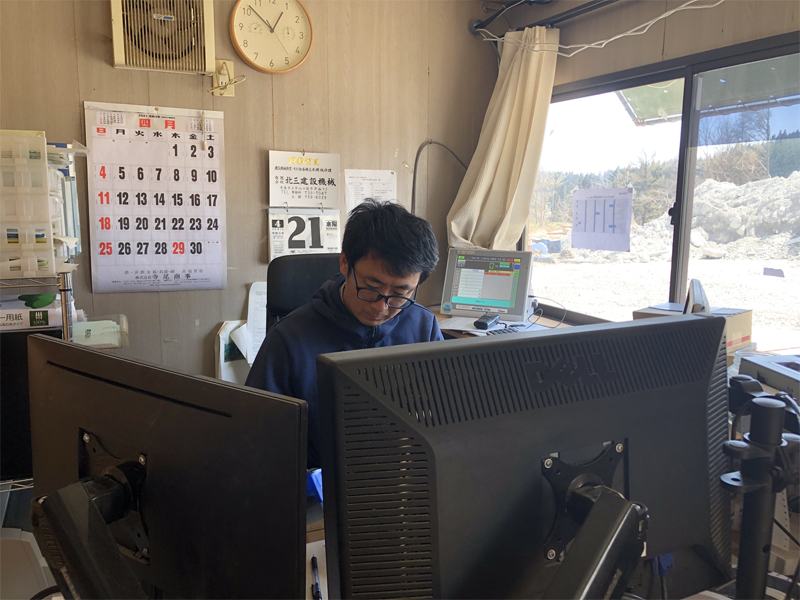 事務所で作業されている三上さん